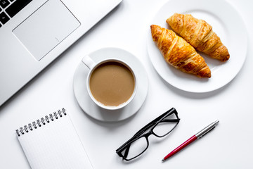 Coffee break in office on desk with laptop top view