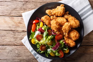  deep-fried chicken wings in breadcrumbs and fresh vegetable close-up. horizontal top view © FomaA