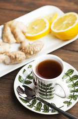 Tea cup with lemon and ginger on white plate. Infusion.