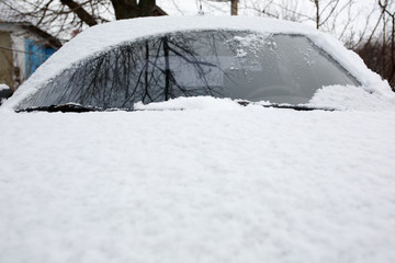 Snow covered frozen car at winter