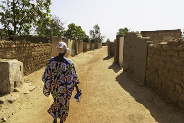 Woman walking in a street of the suburb of Ouagadougou (Burkina Faso)