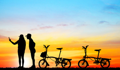 silhouette  Mountain bike and love couple in  the holiday on sunrise time