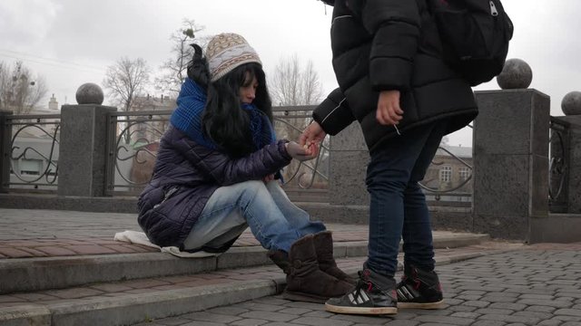 Homeless girl begging alms in the street on a cold winter day