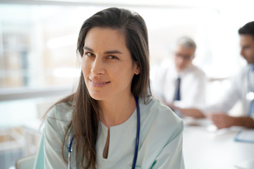 Portrait of nurse, medical team in background