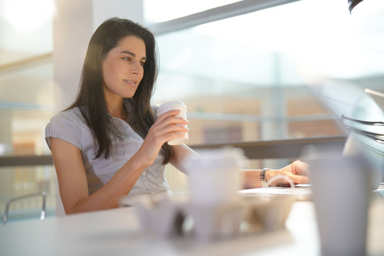 Businesswoman in office drinking coffee