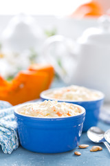 Cooking on kitchen table delicious mini casserole with cottage cheese and pumpkin for breakfast. White background