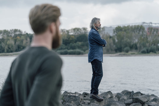 Father and son spending time together at the river, father standing on rocks