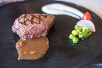 Medium rare meat on plate with sauce