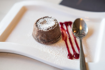 Chocolate lava on plate, with sauce and spoon