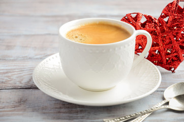 Cup of fresh morning coffee on a wooden background. Valentine's day concept.