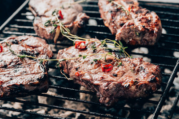 close-up view of delicious juicy meat with spices preparing on grill