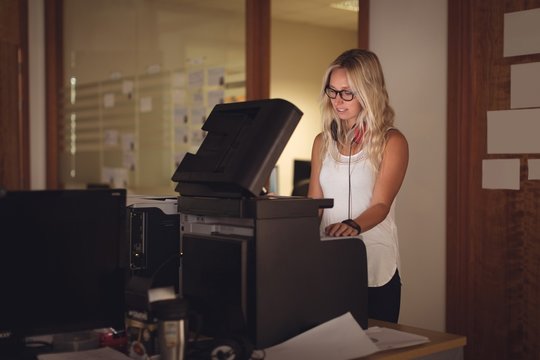 Businesswoman Using Photocopy Machine In Office