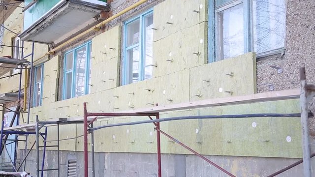 Warming of the apartment house. External repair work on the building, insulation and cladding of the facade of the house