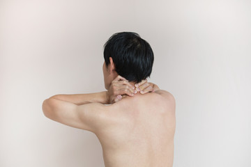 Asian man touches neck pain in the neck, rear view and bad spasm pain. Human health problem concept.
