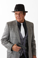 Mafia Guy in Fine Suit with Gun on White Background. An older gentleman in a fine suit with gun in front of a plain, white background..