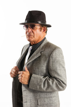 Older Man in Fine Gray Suit and Black Hat on White Background.  An older gentleman in a fine gray suit and black hat in front of a plain, white background..