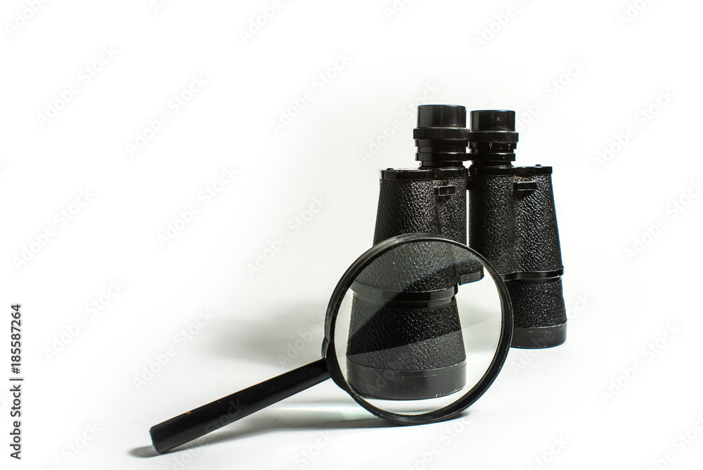 Wall mural black binoculars and magnifier on a white background