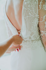 bridesmaid button up a wedding dress. Beautiful bride