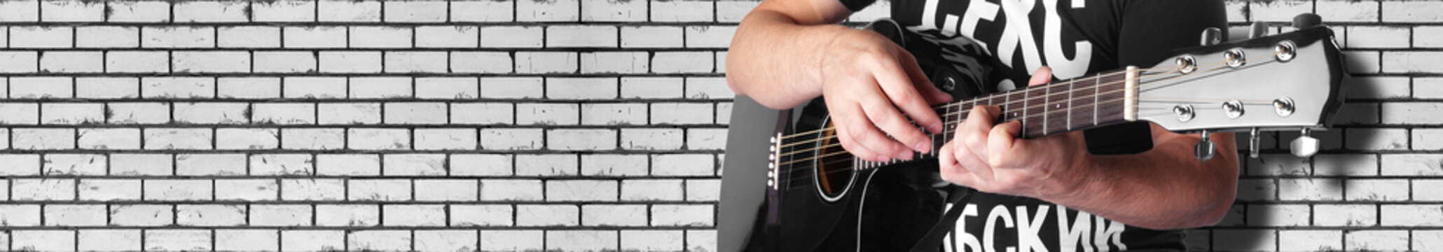 Music - black electric acoustic guitar brick wall
