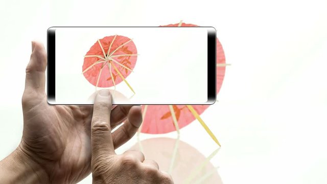 Smartphone with 360 degrees Pink paper cocktail umbrella in rotation