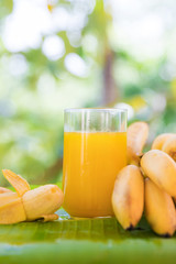 Bunch of bananas on leaf with smoothie juice drink in glass