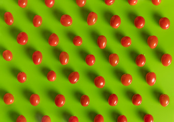 Tasty sweet ripe tomatoes pattern on green background