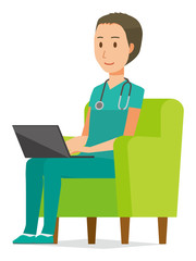 A male doctor wearing a green scrub sits on the sofa and is operating a laptop computer