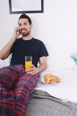 Obraz na płótnie Canvas Man talking on phone in bed.