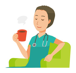 A male doctor wearing a green scrub sits on the sofa and is drinking coffee