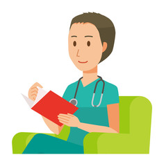A male doctor wearing a green scrub sits on a sofa and is reading books