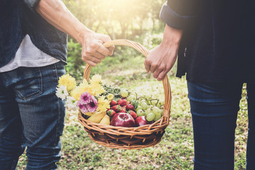 Couple in love walking and holding a picnic basket on nature outdoor background