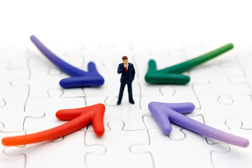 Miniature people standing whit arrow pathway choice. Business decision concept.