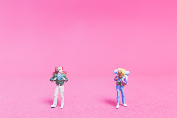 Miniature people : Couple of travellers on pink background&nbsp;, Valentine's day concept