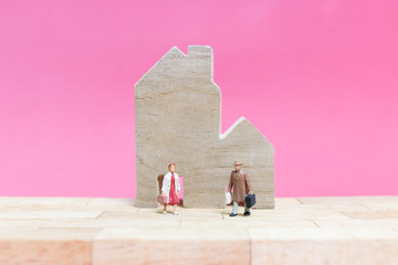 Miniature people : Couple with house on pink background , Valentine's day concept