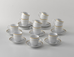gold- rimmed white porcelain set of coffee cups on white background
