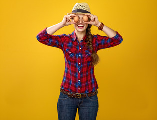 happy woman grower holding eggs in front of face like eyes