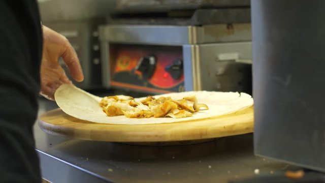 chef making shawarma wrap with meat at kebab shop