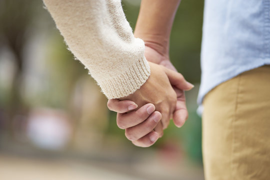 close-up of two people holding hands outdoor showing romance