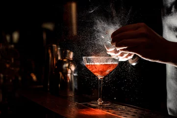 Papier Peint photo Cocktail Mains de barman saupoudrant le jus dans le verre à cocktail