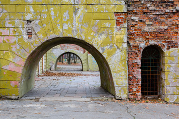 Huge arches in an old brick wall with remnants of plaster