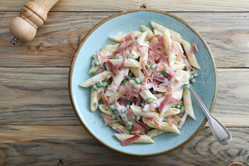 penne prosciutto cotto piselli e formaggio sfondo tavolo di cucina moderno
