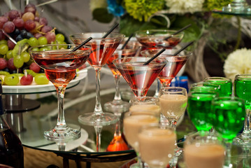 Obraz na płótnie Canvas Glass glasses with colored drinks on the table
