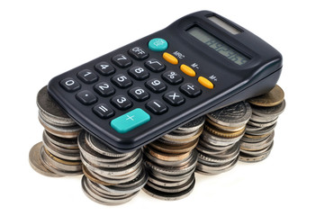 Calculatrice posée sur des piles de pièces de monnaie 