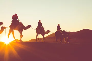 Fotobehang Kameelcaravan met mensen die door de zandduinen in de Sahara-woestijn gaan. Marokko, Afrika. © Curioso.Photography