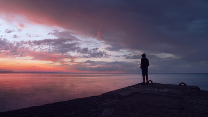 people on the seawall follows the sunset / silhouette of a human landscape of Crimea nature