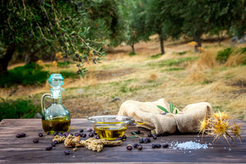 Bowl and bottle with extra virgin olive oil, olives, a fresh branch of olive tree and cretan rusk...