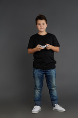 A cute boy in a black T-shirt and a white joystick