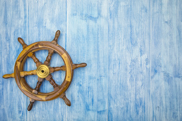 maritime background with helm on blue wood