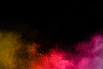 abstract powder splatted background. Colorful powder explosion on black background. Colored cloud. Colorful dust explode. Paint Holi.