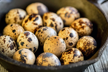 Quail eggs on old brown wooden surface